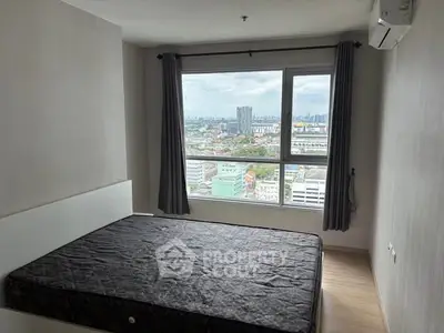 Spacious bedroom with large window offering stunning city views.