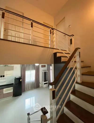 Modern duplex interior with sleek staircase and open kitchen layout.