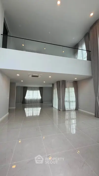 Spacious modern living room with high ceilings and large windows for natural light.
