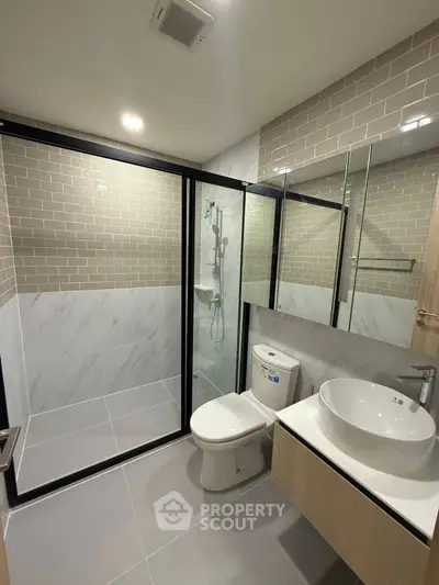 Modern bathroom with glass shower enclosure and sleek fixtures