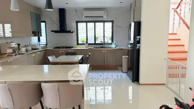 Modern kitchen with sleek cabinetry, island seating, and integrated appliances in a bright open layout.