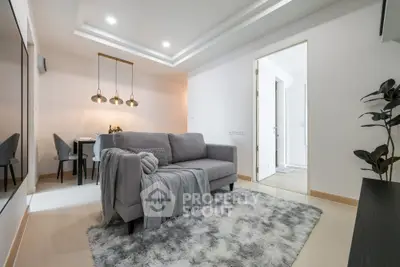 Modern living room with stylish gray sofa and elegant lighting in a cozy apartment.
