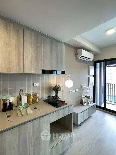 Modern kitchen with sleek cabinetry and balcony access in stylish apartment