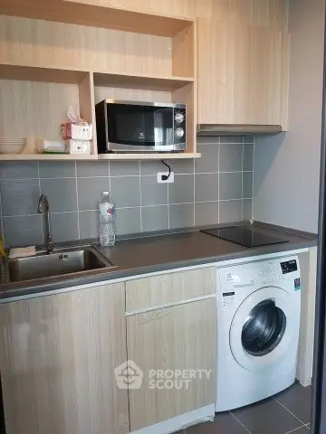 Modern kitchen with washing machine and microwave in compact layout