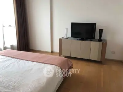 Modern bedroom with sleek TV stand and cozy bed in minimalist design.