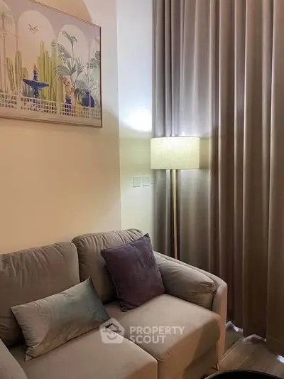 Cozy living room with elegant sofa, floor lamp, and stylish wall art for a modern home ambiance.