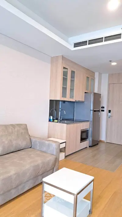 Modern living room with compact kitchen in stylish apartment
