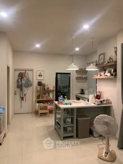 Charming kitchen with open layout and modern lighting, featuring ample storage and cozy decor.