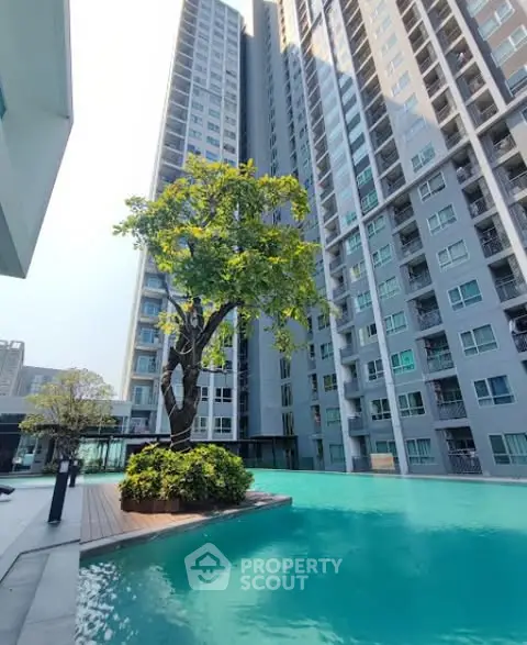 Luxurious high-rise building with serene pool and lush greenery