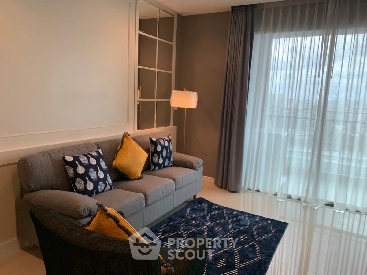 Modern living room with stylish decor and large window offering natural light.