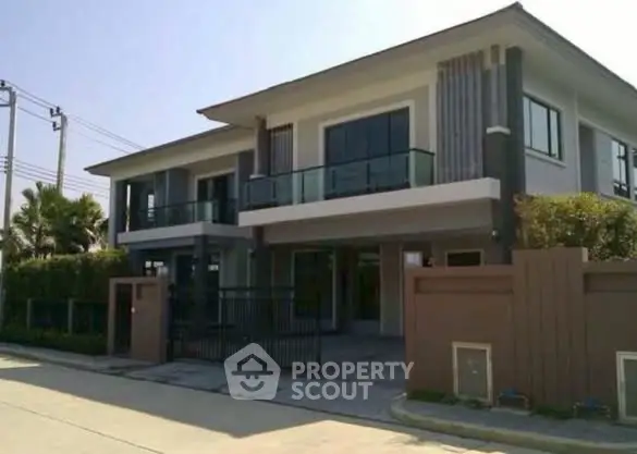 Modern two-story house with sleek design and spacious balcony in a serene neighborhood.