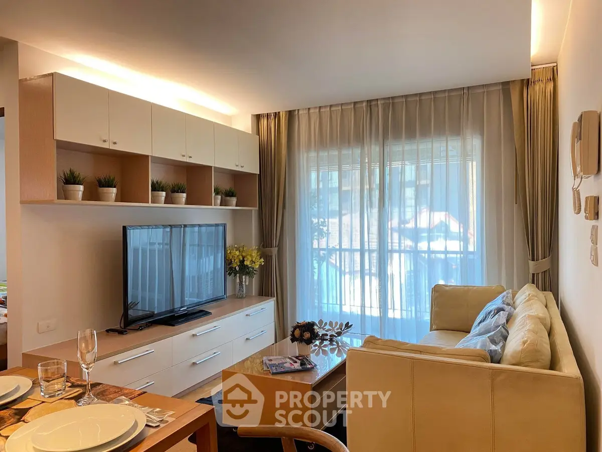 Modern living room with cozy sofa, large TV, and elegant decor in a bright apartment.