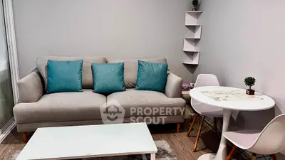 Modern living room with stylish sofa and dining area, featuring elegant decor and cozy ambiance.