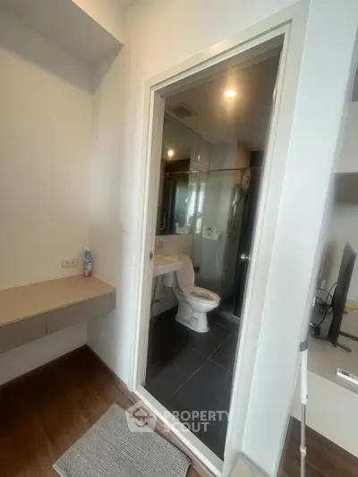 Modern bathroom with glass shower and sleek design in contemporary apartment.