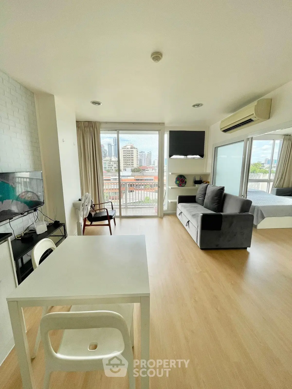 Modern open-plan living room with city view and balcony access