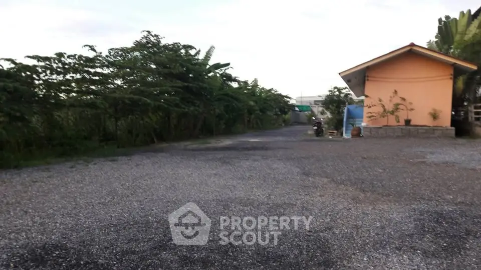 Charming rural property with spacious gravel driveway and lush greenery.