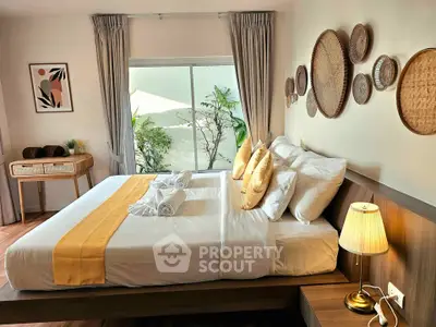 Charming bedroom with stylish decor and garden view, perfect for relaxation and comfort.