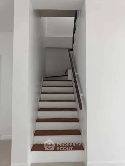 Modern staircase with sleek wooden steps and minimalist design in a contemporary home.