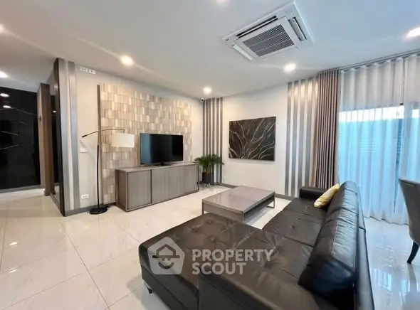 Modern living room with sleek black leather sofa and stylish decor