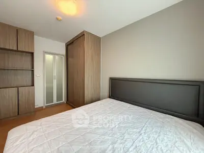 Spacious bedroom with modern wooden wardrobe and cozy bed