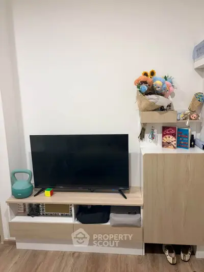 Modern living room with sleek TV stand and decorative shelves, perfect for cozy entertainment setup.