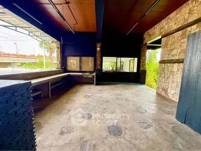 Spacious industrial-style open area with stone walls and concrete flooring, ideal for creative projects.