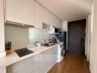 Modern kitchen with sleek cabinetry and built-in appliances in a compact layout.