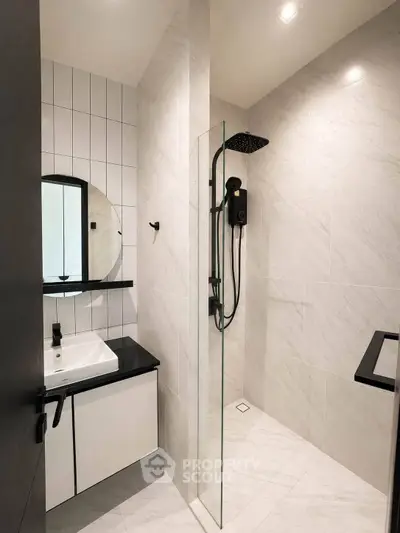 Modern bathroom with sleek shower and stylish vanity in contemporary apartment.
