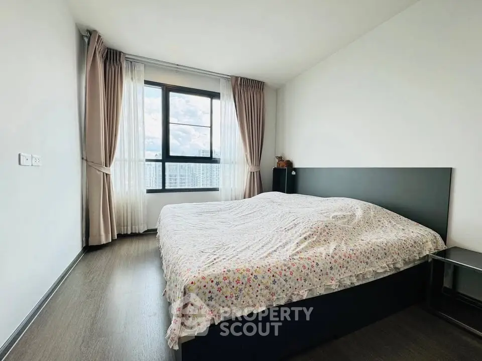 Spacious bedroom with large window and modern decor