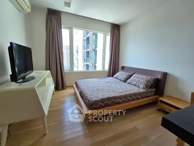 Modern bedroom with large window and stylish furniture in urban apartment