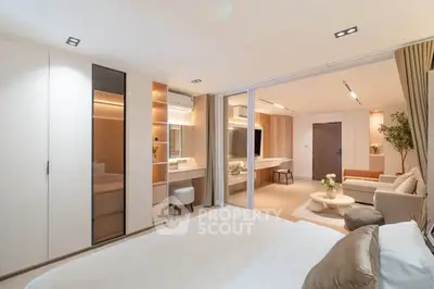 Luxurious modern bedroom with open layout leading to elegant living room, featuring stylish decor and ample natural light.
