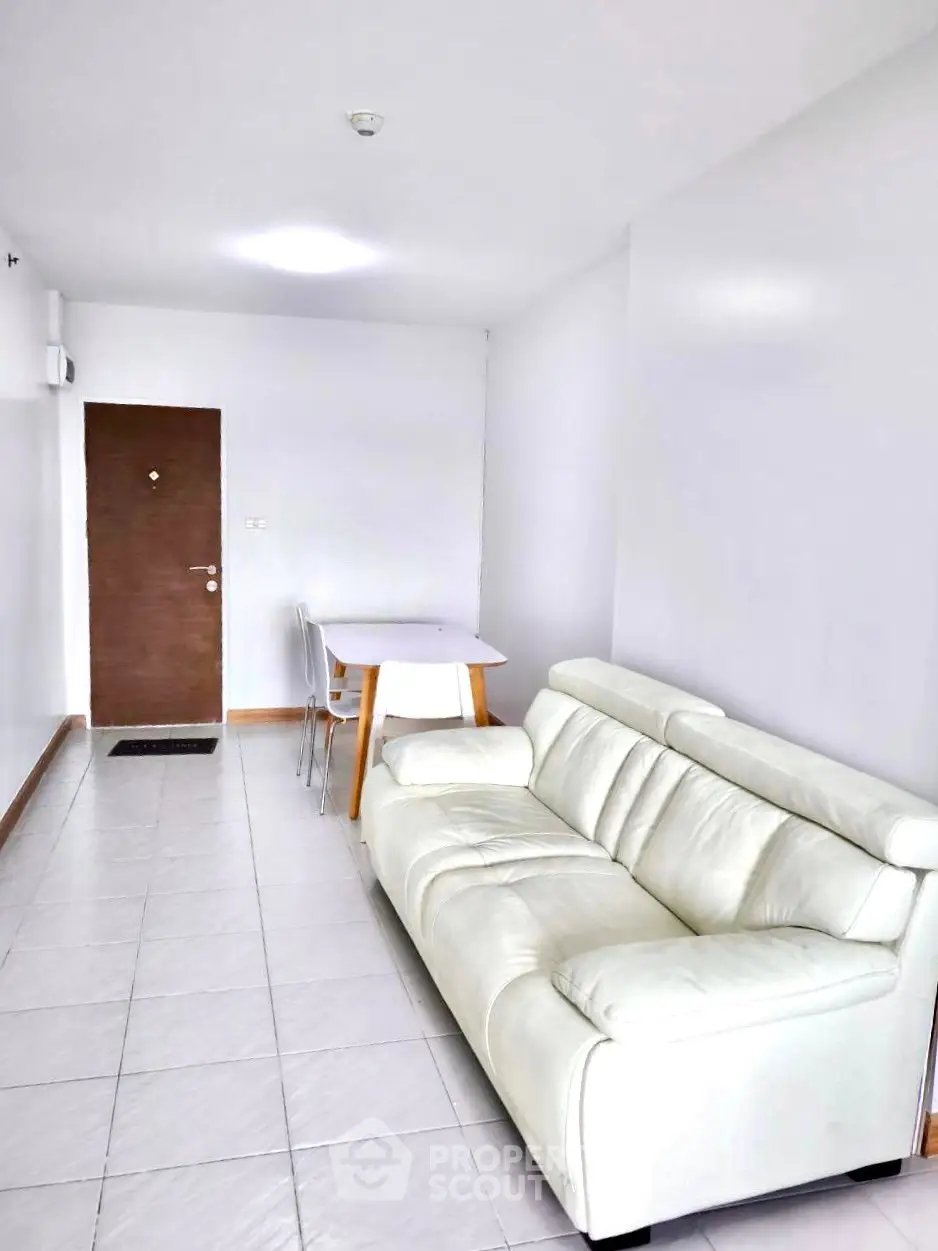 Modern living room with white sofa and dining table in a bright apartment.