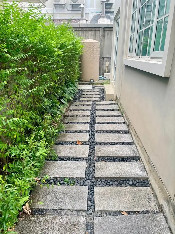Charming garden pathway with lush greenery and modern stone design, perfect for serene outdoor living.