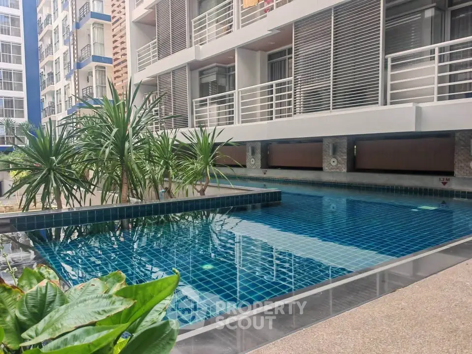 Modern apartment complex with a stylish outdoor pool and lush greenery.