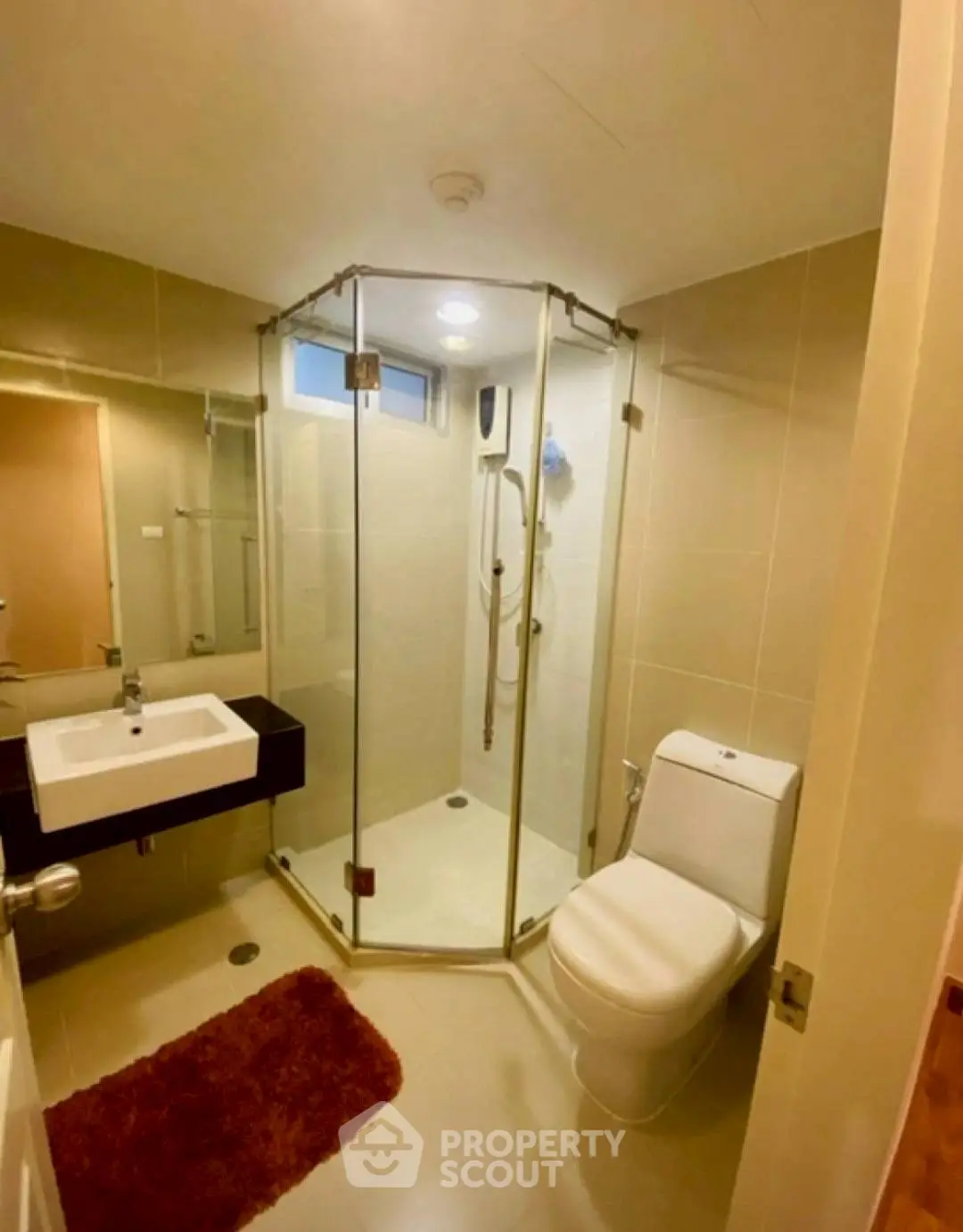 Modern bathroom with glass shower and sleek fixtures in cozy apartment.