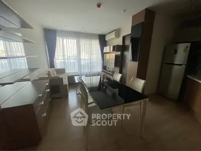 Modern living room with dining area and large windows in a stylish apartment.