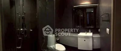 Modern bathroom with sleek fixtures and glass shower enclosure.