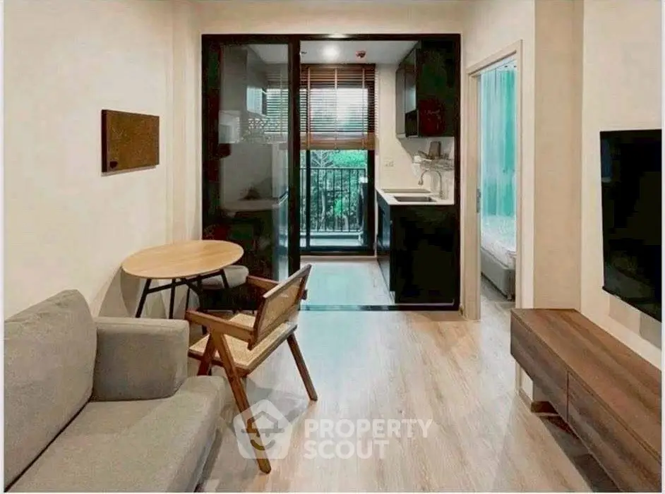 Modern apartment interior with cozy living area and compact kitchen, featuring stylish furniture and natural light.