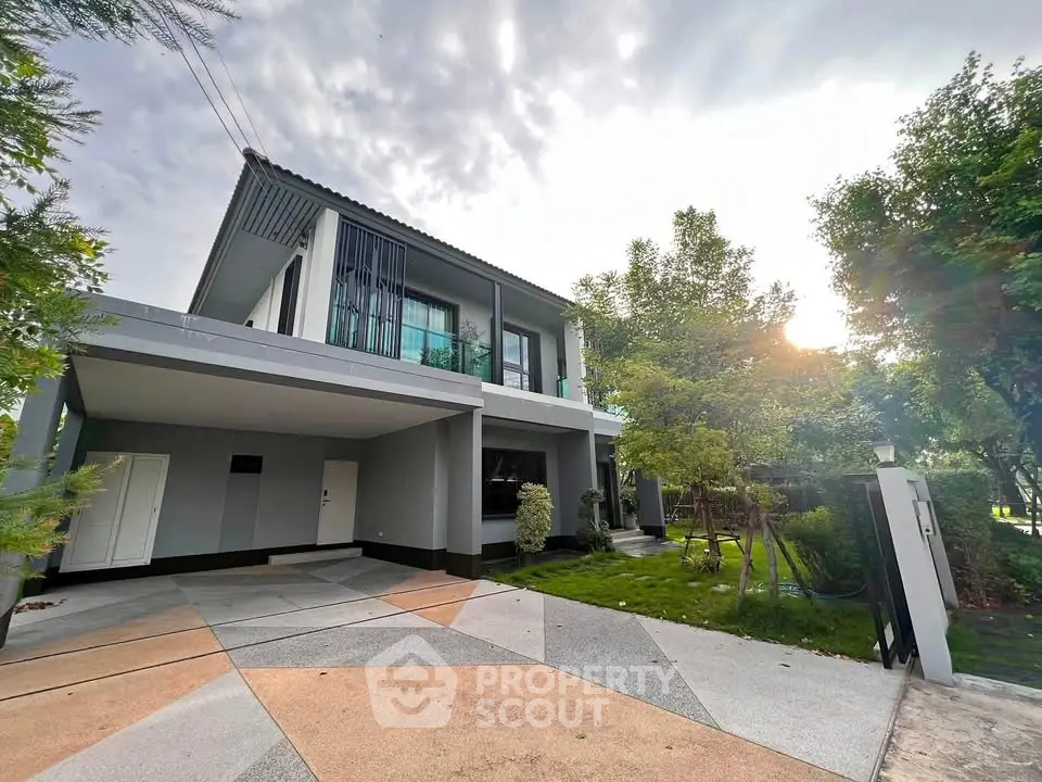 Modern two-story house with sleek design and spacious driveway, surrounded by lush greenery and natural light.