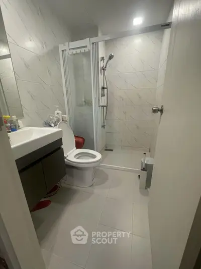 Modern bathroom with sleek shower and elegant fixtures in contemporary apartment.