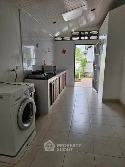 Spacious laundry room with washing machine and outdoor access, ideal for efficient home chores.