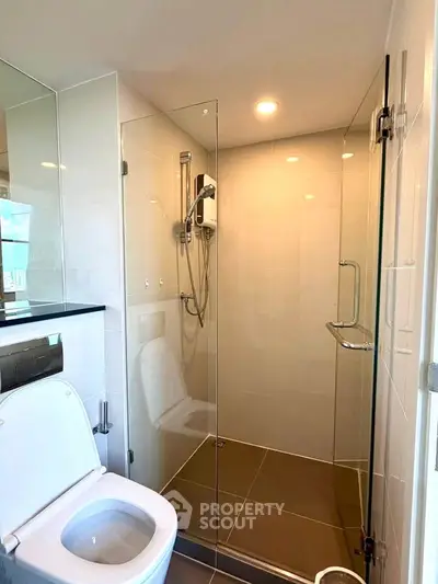 Modern bathroom with glass shower enclosure and sleek fixtures