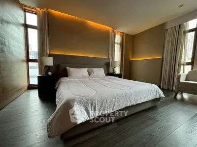 Luxurious bedroom with modern lighting and large windows in upscale apartment.