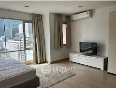 Modern bedroom with city view, featuring large windows, air conditioning, and sleek furnishings.