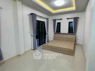 Spacious bedroom with modern design and large windows for natural light.