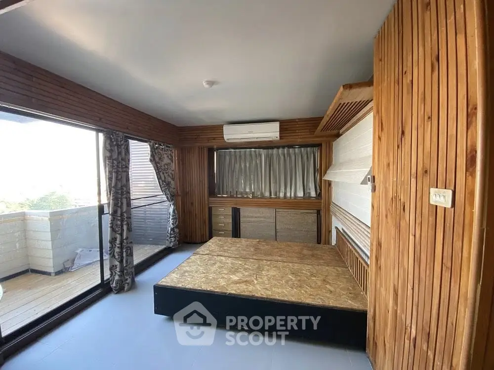 Spacious bedroom with wooden accents and balcony access