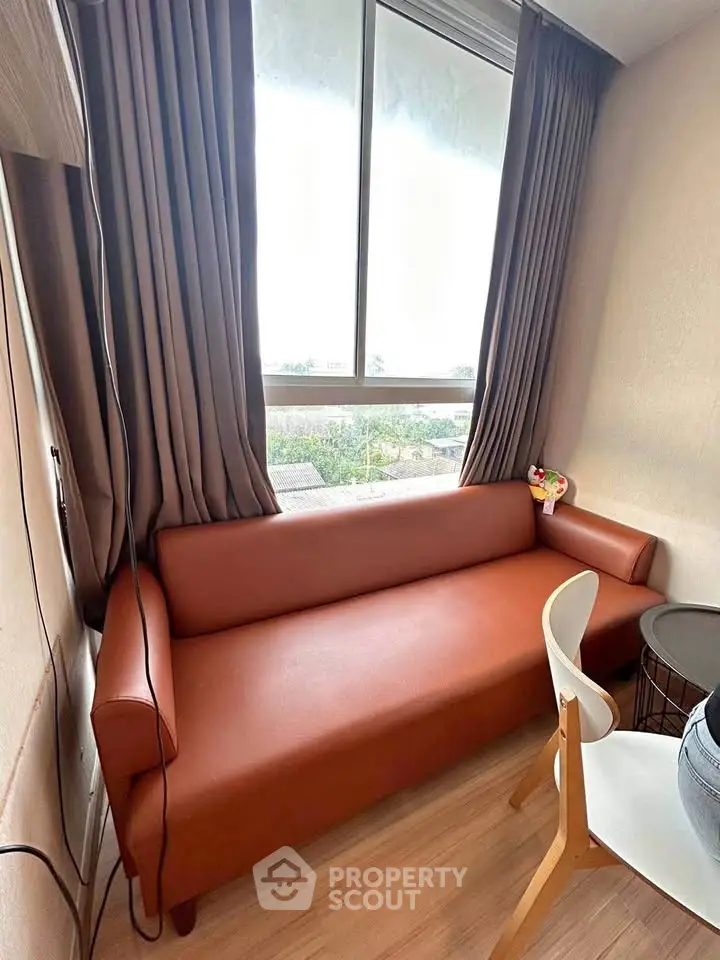 Cozy living room with brown leather sofa and large window view