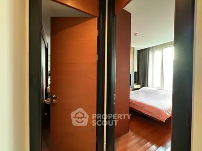 Spacious bedroom with wooden flooring and large windows for natural light