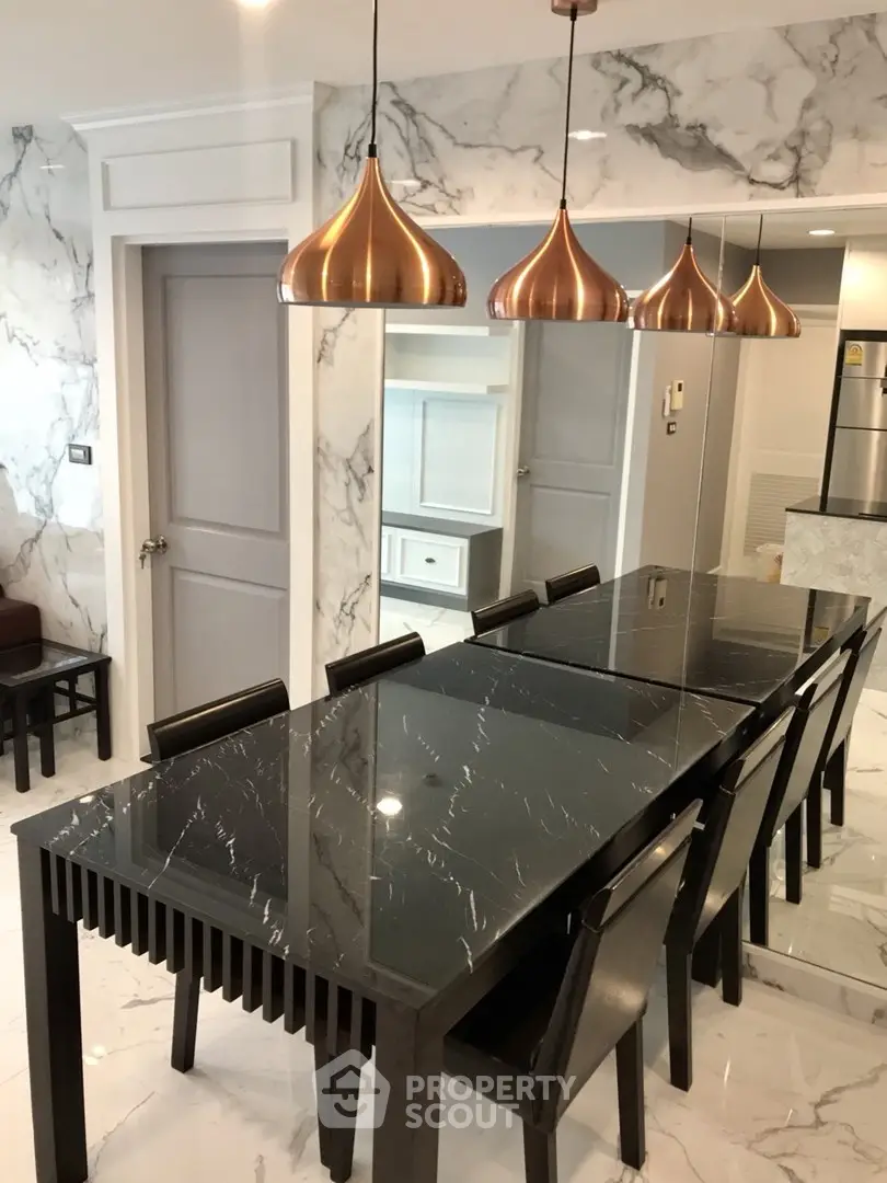 Luxurious dining area with marble accents and elegant lighting in modern apartment.