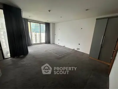 Spacious empty room with large windows and built-in wardrobe, ideal for customization.